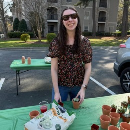 a person smiling while potting a plant